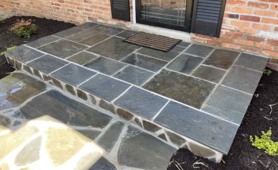 Stone patio with walkway by ProLandscapes MD